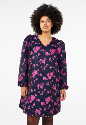 Blommig klänning med marinblå bakgrund och rosa blommor, V-ringning och långa puffärmar. Tillverkad av texturerat tyg, midilängdsdesign.