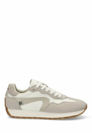 Zapatilla deportiva con parte superior de ante beige, acentos de cuero blanco y suela de goma. Presenta un diseño curvado y texturas contrastantes.