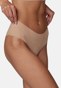 Biancheria intima beige senza cuciture con design a vita bassa, realizzata in un tessuto morbido e liscio. Presenta bordi minimalisti e una cintura elastica.