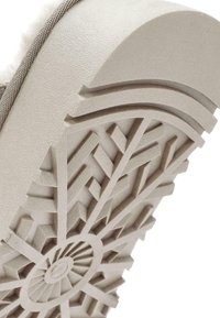 Lichtbeige zool met textuurpatronen, met een cirkelontwerp in het midden en hoekige groeven voor grip.