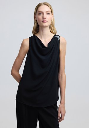 Top negro sin mangas con escote drapeado, que presenta un acento plateado brillante en el hombro. Tejido suave con una textura blanda.