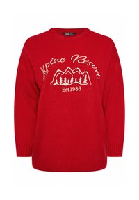 Punainen neulepaita pyöreällä kaula-aukolla, jossa on valkoiset tekstit "Alpine Resort" ja vuoristokuva, sekä ribbausta hihansuissa ja helmassa.