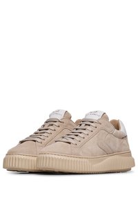 Sneaker beige in suede con suola in gomma texture, design con lacci e linguetta bianca sul tallone; logo visibile su una linguetta nella parte superiore.