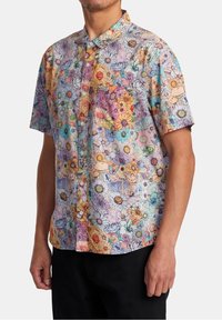 Košile s krátkým rukávem na knoflíky s květinovým potiskem v pastelových barvách, s náprsní kapsou, vyrobená z lehké látky a volným střihem.
