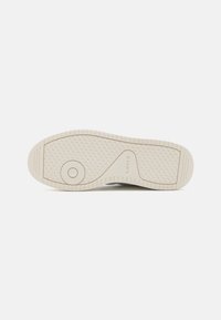 Levi's sneaker sole, rubber material, off-white color, textured surface with patterned tread, circular logo detail on the side.