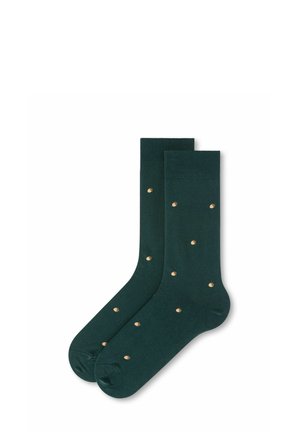 Dunkelgrüne Sportsocken mit kleinen, gleichmäßig verteilten beigen Eichelmotiven auf dem Stoff.