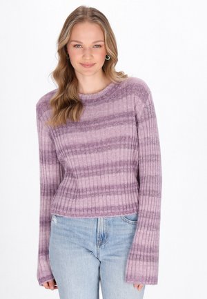 Lila gestreifter Pullover mit gerippter Textur, rundem Ausschnitt und langen, ausgestellt geschnittenen Ärmeln. Kombiniert mit hellblauen Jeans.
