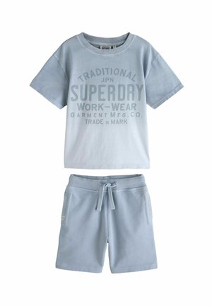 Camiseta de algodón azul claro con un gráfico de "Superdry Work-Wear"; combinada con pantalones cortos a juego que tienen una cintura elástica y cordón.