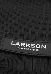 Zwart textiel met een opvallend horizontaal zwart leren label waarin de woorden "LARKSON HAMBURG" in witte letters zijn gedrukt.