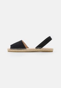 Svart mocka slingback-sandal med öppen tå, sula av jute-rep och en kontrasterande inredning av naturläder. Har en platt och bekväm design.