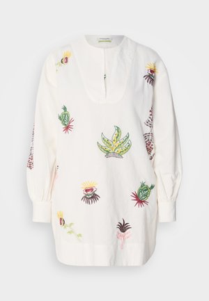 Tunica bianca con ricamo botanico multicolore intricato, caratterizzata da uno scollo a girocollo e maniche lunghe arricciate.