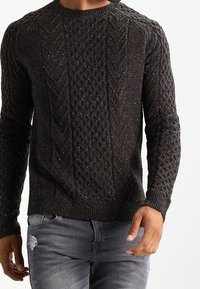 Dunkelgrauer Strickpullover mit Zopfmuster, rundem Ausschnitt und strukturierten, gerippten Bündchen. Schmale Passform mit leicht schimmerndem Material.