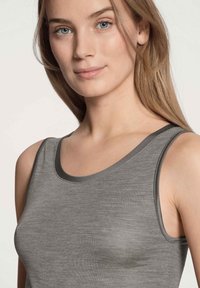 Grijze tanktop met een gladde textuur, voorzien van een ronde halslijn en donkergrijze bies langs de randen. Lichtgewicht stof die geschikt is voor het dragen in lagen.
