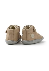 Scarpe in pelle marrone chiaro con suole in gomma grigia, design alto, chiusura laterale e un accento con logo circolare sul tallone. Interno morbido.