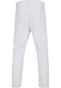 Valged puuvillased püksid, kitsas lõige, varustatud tagataskutega, sujuva tekstuuriga ja puhta disainiga. Ilma nähtavate kaunistusteta.