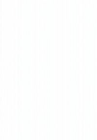 Person sitter med benen i kors på golvet och skriver på en bärbar dator, med böcker, växt, hörlurar och ett litet bord med högtalare i närheten i ett ljust rum.