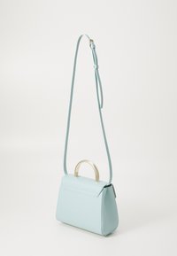 Borsa a mano blu chiaro con forma strutturata, manico metallico e tracolla regolabile. Texture in pelle liscia con accenti di design minimalista.