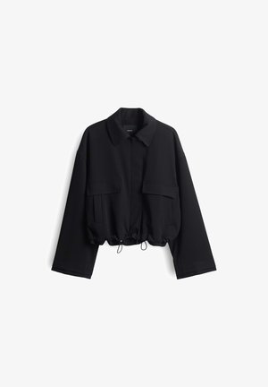Zwarte kort gesneden jas met lange mouwen, twee voorzakken met klep, kraag en verstelbare trekkoorden aan de onderzijde.