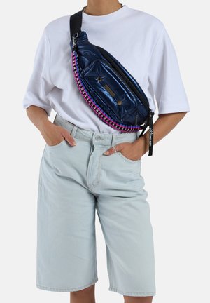 Sac bandoulière rembourré bleu marine avec un détail de fermeture éclair tressé rose et noir. Il dispose d'une poche frontale et d'une sangle noire ajustable. Matériau lisse et brillant.