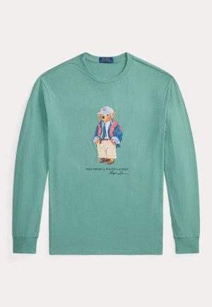T-shirt vert menthe à manches longues et à col rond, avec une image centrale d’un ours habillé, portant la mention Polo Bear by Ralph Lauren.