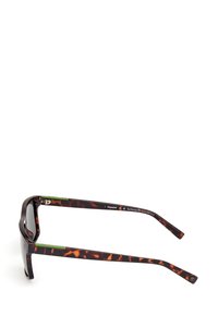 Okulary przeciwsłoneczne z ciemną, żółwiową oprawą, wyściełanymi zausznikami w kolorze zielonym oraz kwadratowymi soczewkami, odpowiednie do różnych aktywności na świeżym powietrzu.