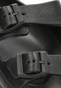 Sandalias negras con correas texturizadas, dos hebillas ajustables, plantilla contorneada y superficie interna suave.