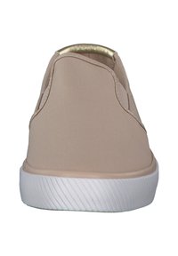 Beżowe trampki z płótna o gładkiej teksturze, zaokrąglonym kształcie i białej gumowej podeszwie. Posiadają metaliczny akcent przy kołnierzu.