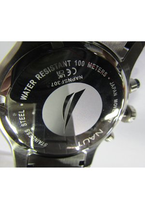 Nerūsējošā tērauda pulksteņa aizmugure ar uzrakstu "Ūdensizturīgs 100 metri", sudraba logo un iegravētām detaļām. Apaļa forma ar gludu tekstūru.