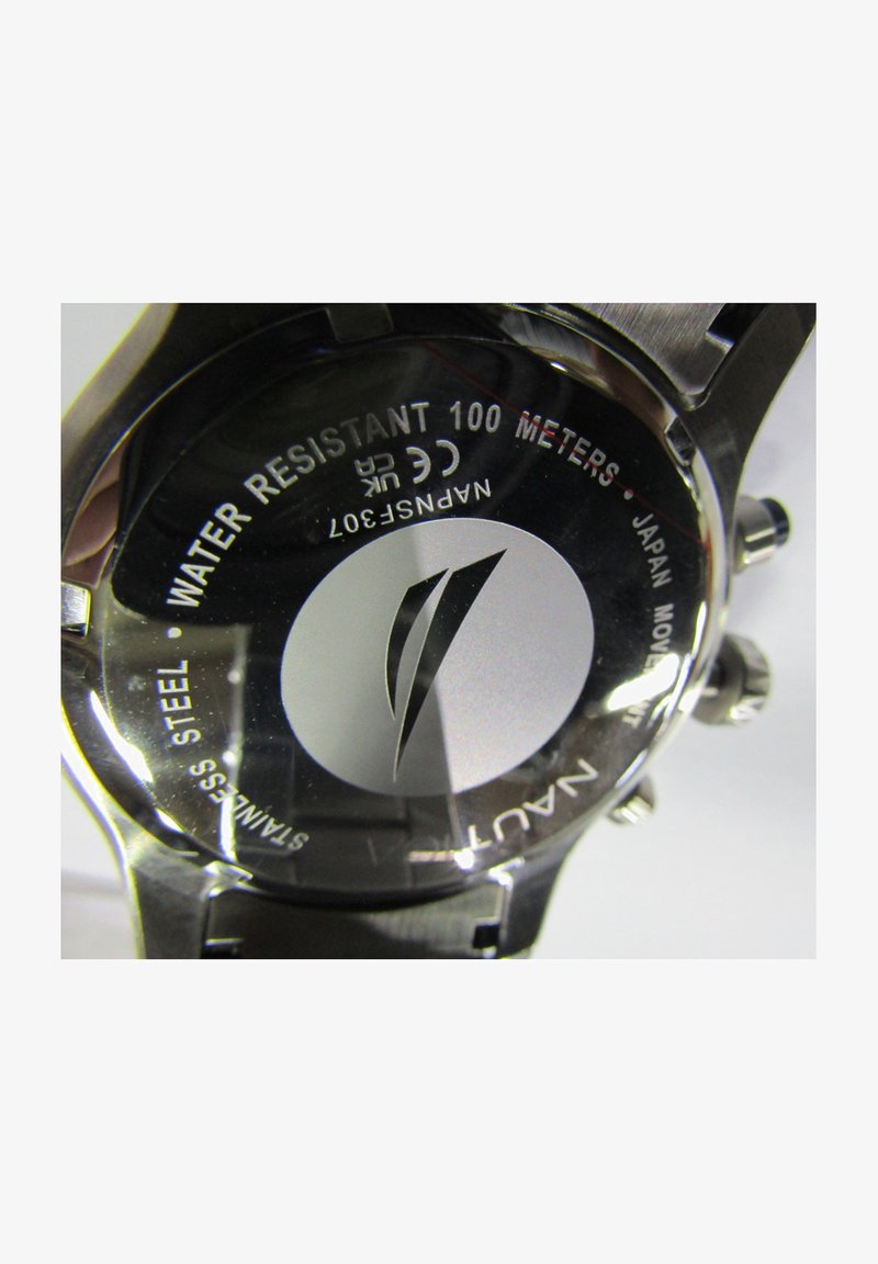 Nerūsējošā tērauda pulksteņa aizmugure ar uzrakstu "Ūdensizturīgs 100 metri", sudraba logo un iegravētām detaļām. Apaļa forma ar gludu tekstūru.