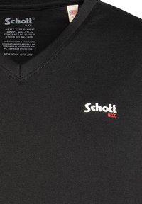 Zwarte V-hals t-shirt van katoen, met een klein wit en rood geborduurd logo "Schott NYC" op de linkerkant van de borst. Eenvoudig, getailleerd ontwerp.