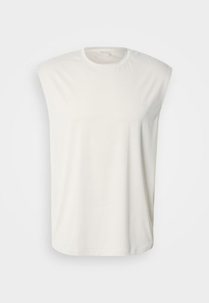Bílé tílko bez rukávů s kulatým výstřihem, vyrobené z texturované látky. Má jemný detail s logem. Volný střih s rovným okrajem.