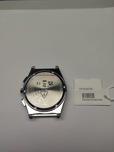 Nerūsējoša tērauda pulksteņa korpuss ar apaļu formu un pulētu apdari. Aizmugurējā daļā ir marķējumi, logo un modeļa numurs uz baltas krāsas fona.