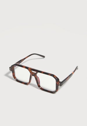 Lunettes rectangulaires en écaille de tortue avec des montures épaisses et des verres clairs, présentées sur un fond clair.