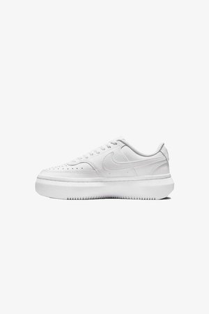 Białe sneakersy z gładką skórzaną cholewką, okrągłym noskiem, perforowanymi detalami i grubą, białą gumową podeszwą. Posiadają logo na boku oraz płaskie sznurówki.