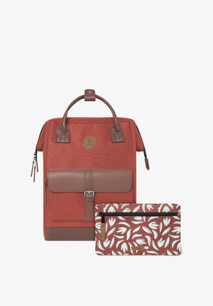 Sac à dos en tissu rouge avec des accents en cuir marron, présentant un rabat à l'avant et une pochette détachable à motif floral. Poignées doubles et fermeture éclair.