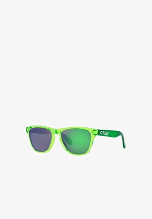 Occhiali da sole in plastica verde trasparente con lenti scure, forma angolare e marchio "Oakley" sull'astina. Accenti verdi riflettenti.