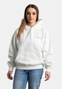 Felpa bianca con cappuccio, dotata di tasca frontale, polsini e vita a costine; presenta un piccolo logo ricamato sul petto.