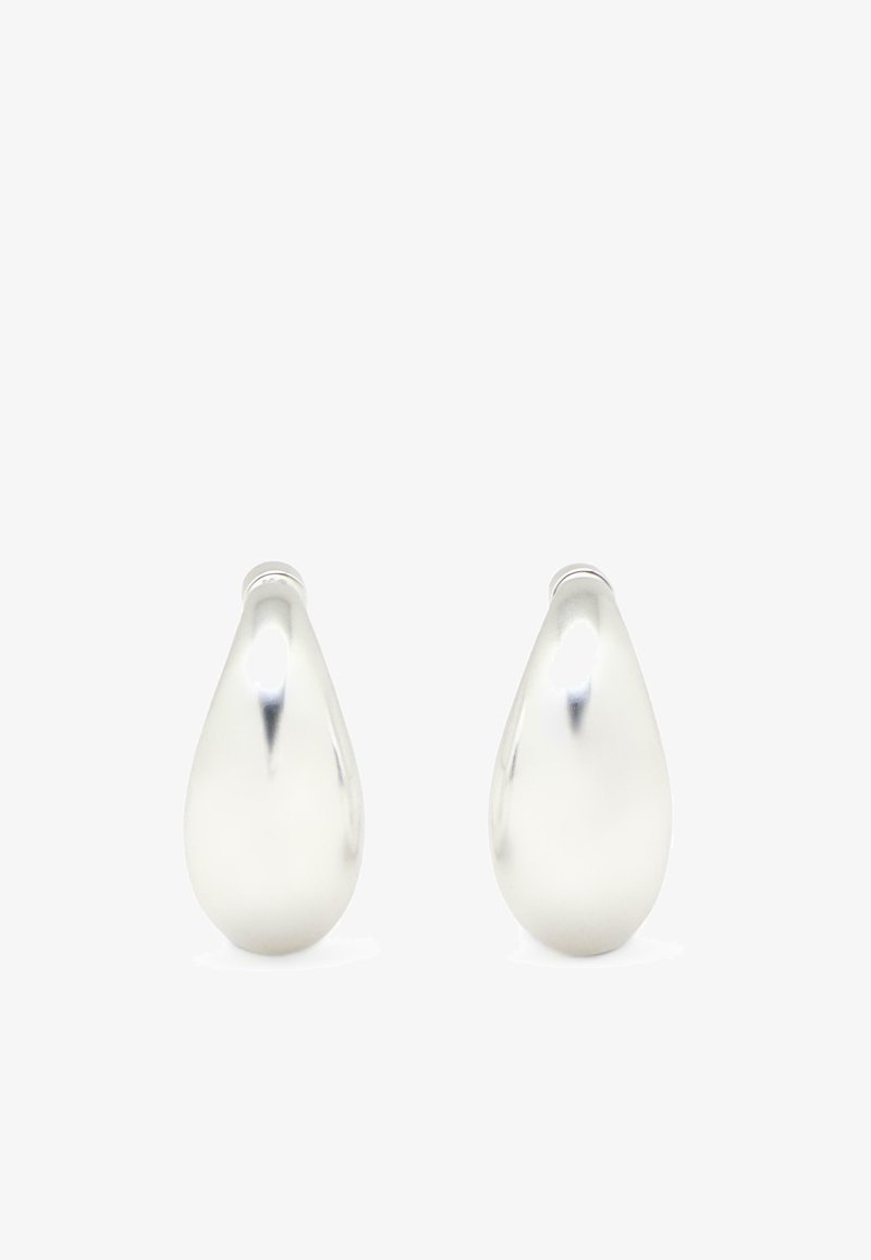 Paire de boucles d'oreilles clous lisses et polies en argent en forme de goutte avec des surfaces courbes et réfléchissantes sur fond blanc.