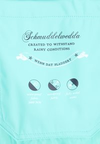 Jasnoniebieska kurtka wykonana z wodoodpornego materiału o ratingu 3000 mm. Wyposażona w cechy wiatroszczelne oraz w pełni szczelne szwy; nadrukowany tekst i ikony.