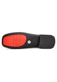 Semelle de chaussure noire avec une accent rouge comportant du texte, taille 38. Le texte comprend "chaussures de mode." Texture lisse avec une légère adhérence sur le bord.
