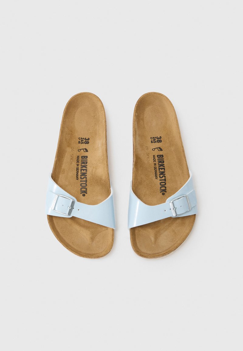 Lichtblauwe, gepatineerde leren slide sandalen met een enkele brede strap met een zilveren metalen gesp. Korken voetbed met een gestructureerde afwerking.