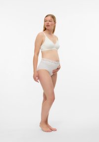 Ελαφρύ κρεμ σουτιέν με απαλό, λείο υλικό και V-λαιμόκοψη. Τα αντίστοιχα ψηλόμεσα σλιπ έχουν διακοσμητική λωρίδα με λουλουδάτη δαντέλα στη μέση.