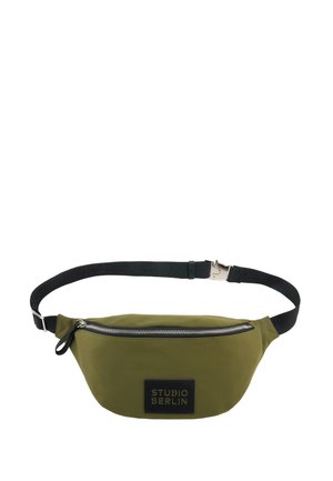 Olivgrüne Bauchtasche mit schwarzem verstellbarem Riemen, silbernem Reißverschluss und schwarzem Aufnäher mit der Aufschrift "STUDIO BERLIN" vorne.