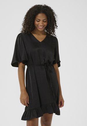Robe noire cintrée avec des manches courtes et légères en volants, et un ourlet évasé. Fabriquée à partir d'un matériau lisse et léger avec une taille nouée. Design en V.