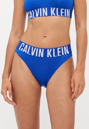 Calvin Klein blauwe bikini set met een effen kleurontwerp, een band met gaasrand en een opvallend merklogo op de tailleband. Gladde textuur.