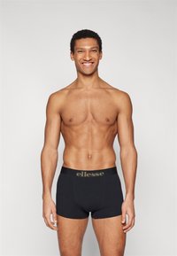 Black boxer briefs with a wide black waistband featuring the brand name "ellesse" in gold lettering. Smooth texture and fitted design.