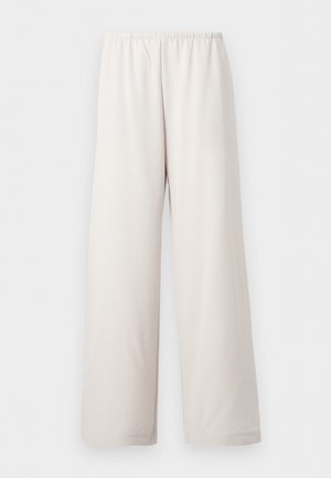 Χαλαρά κρεμ παντελόνια με ελαστική μέση και ίσια φαρδιά μπατζάκια, παρουσιάζονται σε απλό λευκό φόντο.