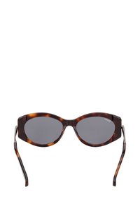 Eleganti occhiali da sole ovali in acetato tartarugato con lenti scure e sottili braccia curve su uno sfondo bianco.