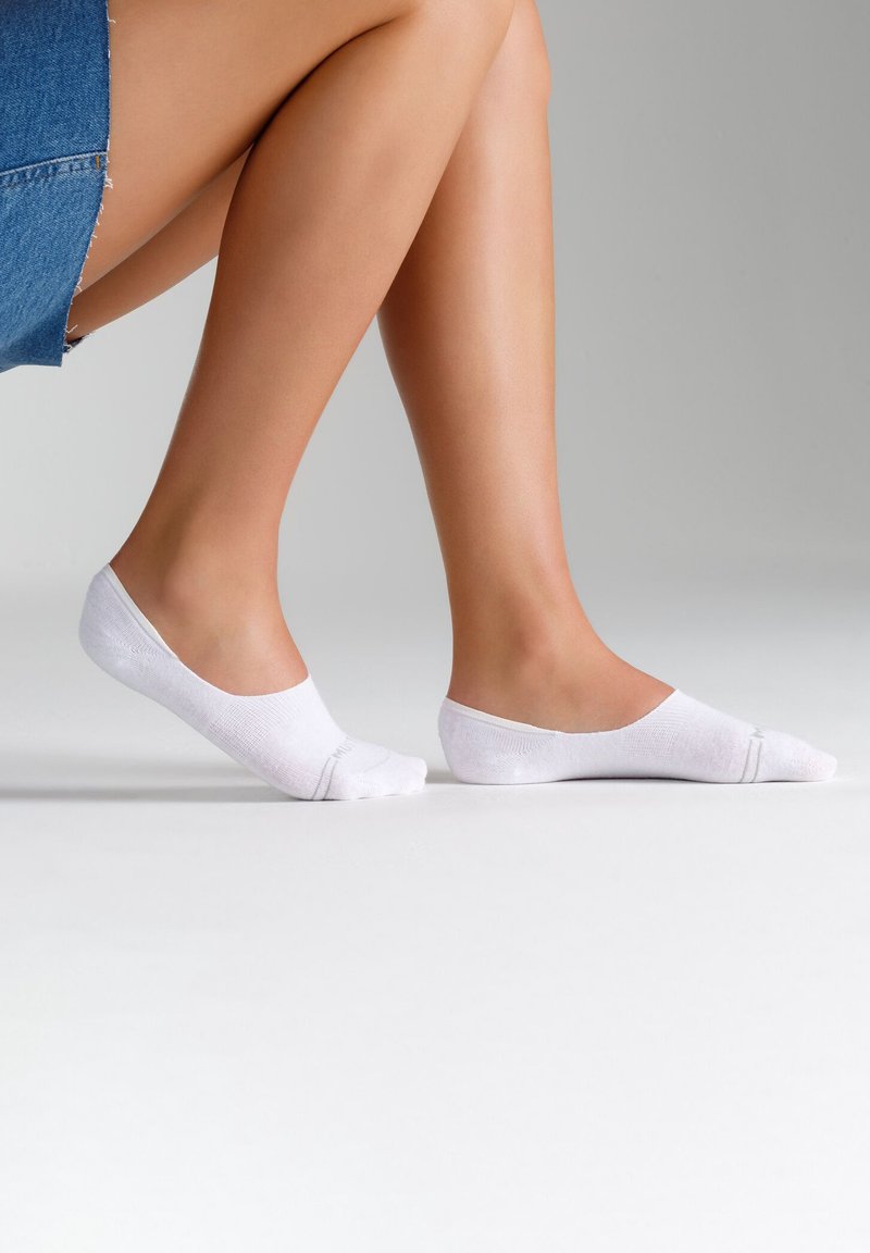 Weiße No-Show-Socken aus einem weichen, strukturierten Stoff mit einem niedrig geschnittenen Design. Sie verfügen über verstärkte Zehen und eine glatte Ferse für zusätzlichen Komfort.