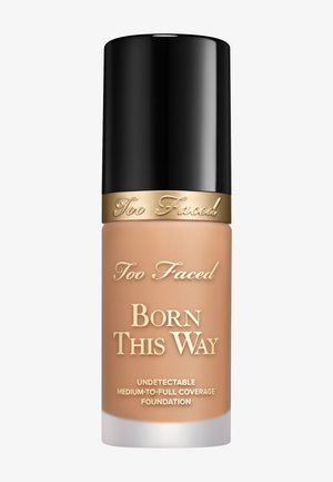 Foundation-Flasche mit einem schwarzen zylindrischen Deckel und einem matten beigen Körper. Auf der Vorderseite steht in Goldschrift "Too Faced Born This Way" mit Produktdetails darunter.